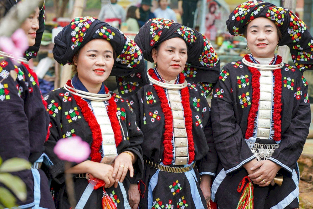 Dao women in traditional dress showcase their intricate embroidery